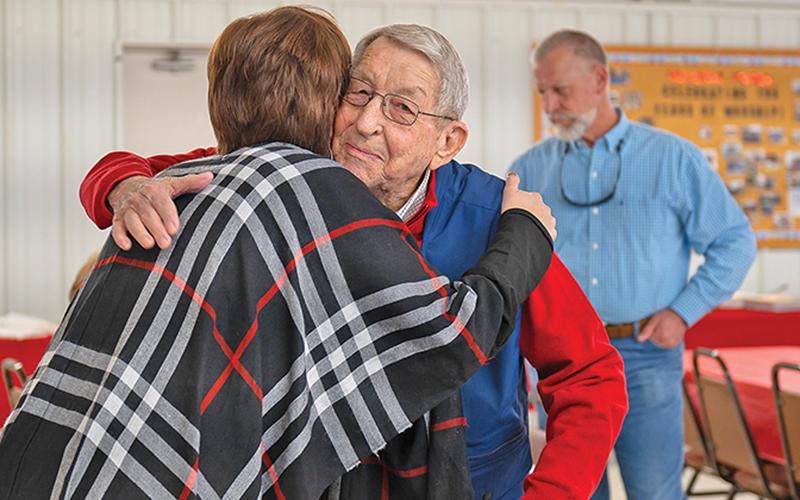 Lewis Canup embraces his granddaughter Kelli Mayes at his 90th birthday party. Canup retired in 2015 after working as the Habersham County Administrator/Manager and Engineer.