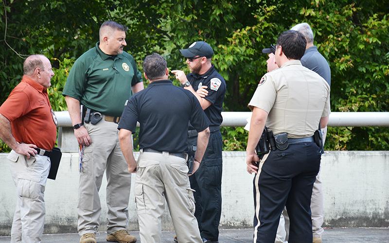 Officers discuss the body found in Clarkesville on Thursday afternoon.