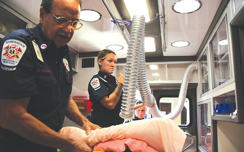 Habersham Emeregency Services Paramedic Dave Kinnunen, advanced EMT Courtney Fortner and critical care paramedic Scott Boleman give a tour of one of their ambulances. Kinnunen shows one of the hoses they use for COVID-19 patients to breathe into.