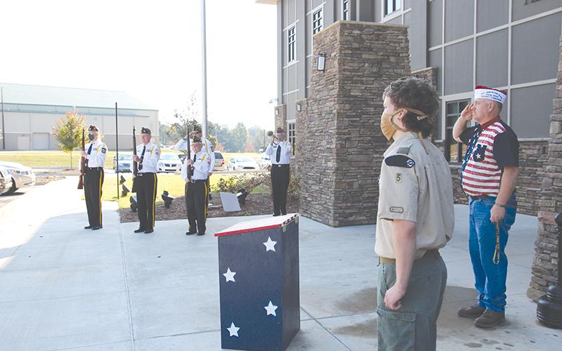 Grant Reeves VFW Post 7720 Commander Bill Miles (right) and Eagle Scout Joseph McNair stand at attention while the VFW Honor Guard plays “Taps” at Tuesday’s dedication ceremony for the flag retirement boxes.
