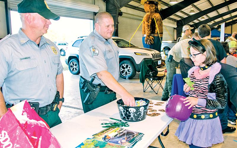 Georgia Department of Natural Resources officers Chad Chambers (left) and Joe Hill offer candy to a cool cat at last year’s E-911 Halloween event in Habersham County. The event has been cancelled for this year due to lingering COVID-19 concerns.