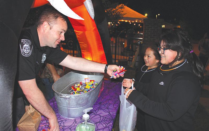 Baldwin interim police chief Matt Nall hands out candy to Bere Ortega and Elizabeth Aguilar at the final trunk-or-treat stop during Baldwin’s fall festival Wednesday night. The festival, hosted by Baldwin Baptist Church and the Baldwin Police and Fire departments, saw much of the community come out for a night of trunk-or-treating, food and fellowship.