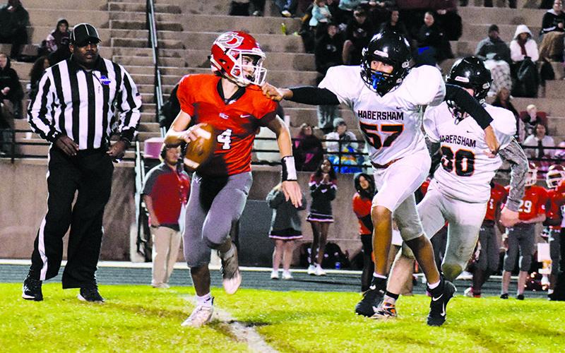 Judge Wilbanks (57) pressures Indians' quarterback Tripp Underwood (14) on one of his only pass attempts of the night to keep the game knotted at 14-14 going into halftime. ISAIAH SMITH/Staff