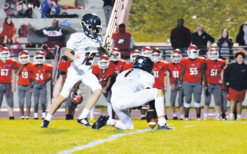 Raiders holder Zeke Whittington (1) sets the ball down for Michael Hill’s (12) game-winning field goal. The kick gave Habersham the 24-22 victory over Stephens County for the championship.