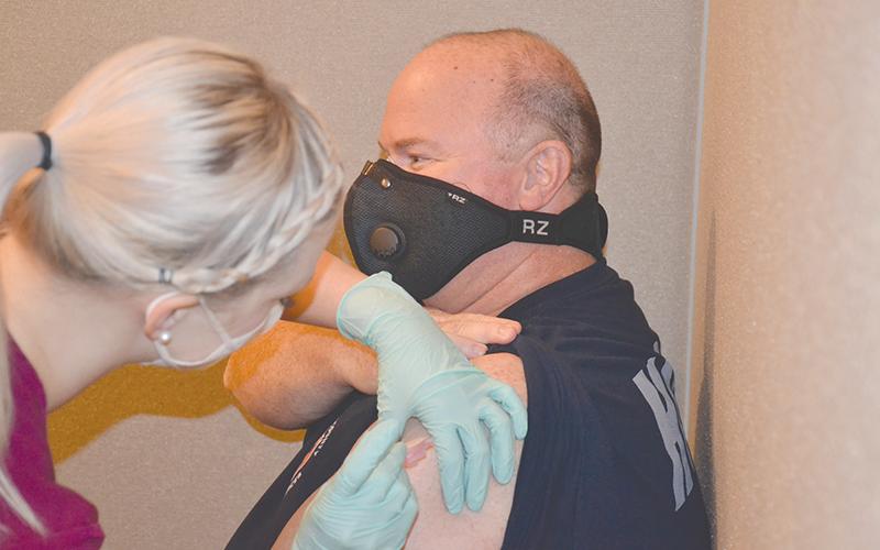 Habersham Emergency Services paramedic Greg Ramey gets his COVID-19 vaccine Wednesday from nurse Lauren Martin at Habersham Medical Center.