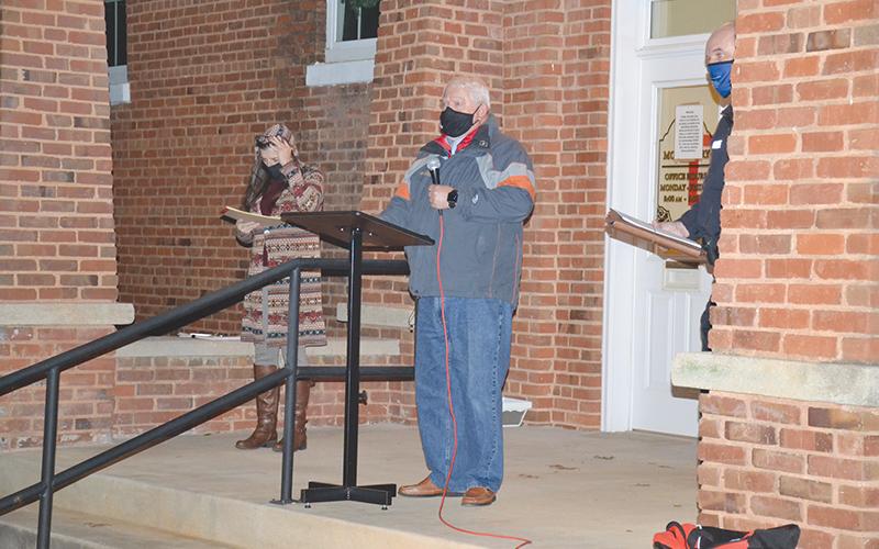 Mt. Airy Mayor Gary Morris addresses the town council in cars Monday with Sheri Berrong (left) helping keep things running in chilly weather.