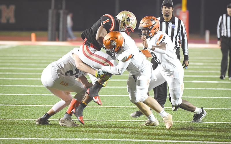 Habersham Central tacklers (from left) Grayson Taylor, Patrick Tedder and Alex Aaron  converge on Rome’s EJ Lackey during Friday’s playoff game. TOM ASKEW/Special