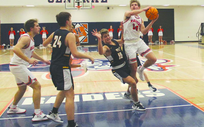 Senior guard Grant Tipton takes absorbs a foul before finishing the layup during Monday night’s Raider victory over Prince Avenue.