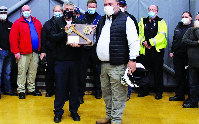 Habersham County EMS Director Chad Black (left) presents Jeff Cain (right) with a plaque commemorating his years of service while surrounded by the County's EMS workers. Black also thanked Cain for his work in helping merge the county's firefighters and EMS into a single department like it is today.