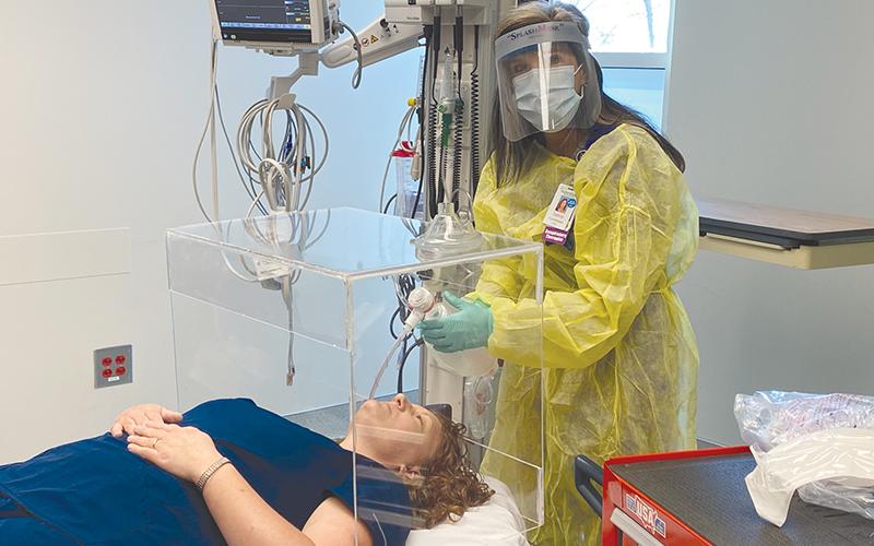 Jamie  Mentzer uses an  intubation box and practices placing a breathing tube into a COVID-19  patient that is unable to breathe on their own. HABERSHAM MEDICAL CENTER/Submitted