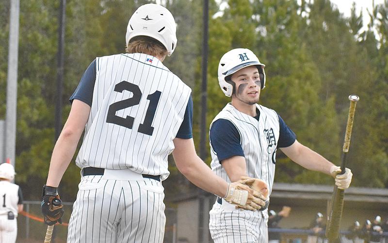 Logan Bogue congratulates Azzi Cervantes after scoring one of the Raiders’ five runs in the second inning of Wednesday’s game against the Franklin County Lions.