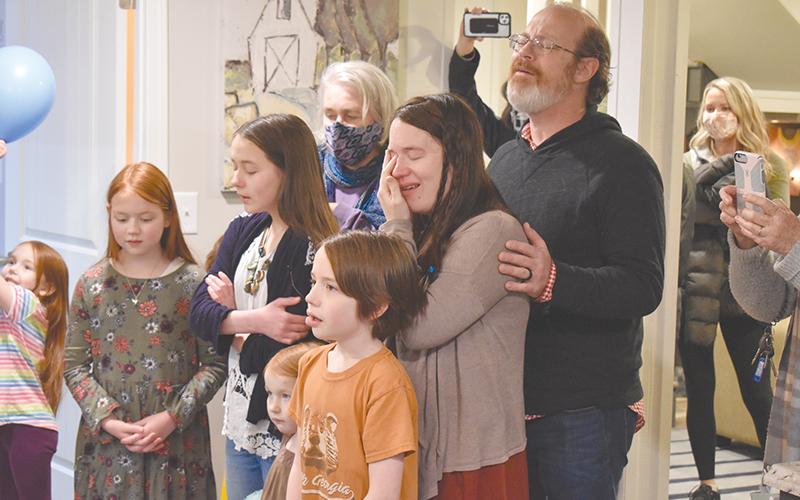Randy Chester and his family lead friends and volunteers in song after they helped renovate their family's basement into an entirely new living space.