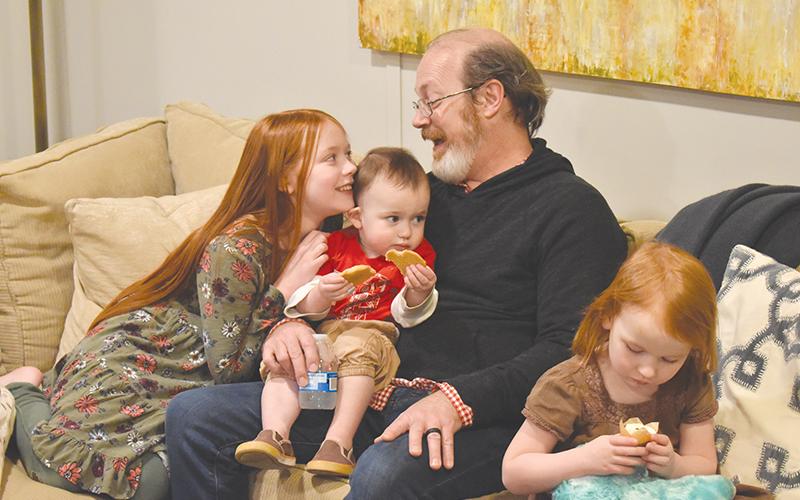 Randy Chester shares a smile with daughter Paloma as little guy Rune samples the cookies and Azalea checks out a cupcake to celebrate their new space.