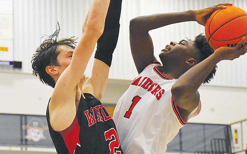 Habersham Central’s Bryce Pittman (right) goes up for a shot with a Winder-Barrow defender draped all over him during Tuesday’s game.