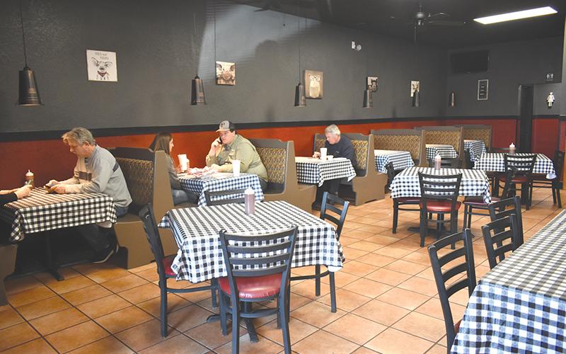Customers enjoy a meal at Wolf Creek BBQ’s new location since a fire destroyed its former building in Cornelia and forced it to close for four months.