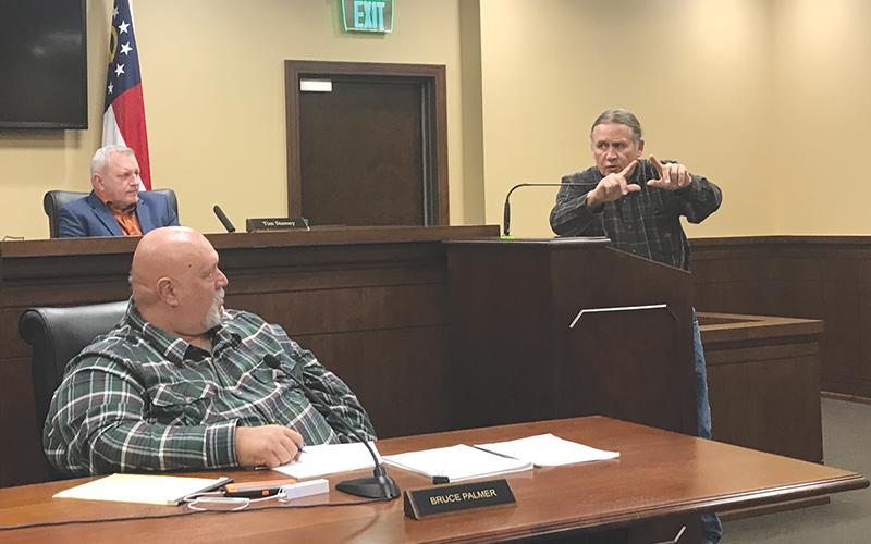 Mark Alley tries to paint a picture of the proposed cell tower and its proximity to nearby homes at Monday’s meeting while Commissioners Tim Stamey (top) and Bruce Palmer listen..