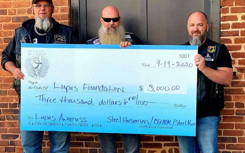Chad Stinchcomb from Steel Horseman M/C of Athens, Amos “Moose” Smith from Steel Kin and Johnny Johnson from Cross Bearers MM of Habersham take a photo with a $3,000 check they helped raise for the Lupus Foundation in 2020.
