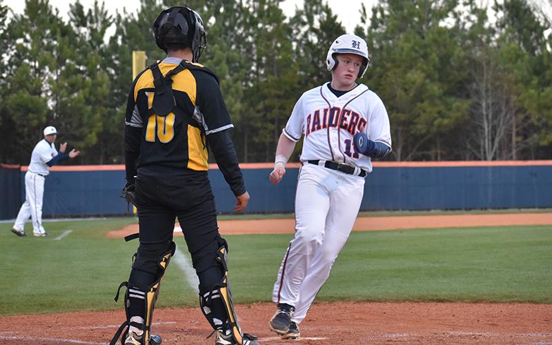 Habersham Central outfielder Austin Jones scores in the second inning on a sacrifice fly from Logan Bogue for one of the 16 runs the Raiders scored Monday night.