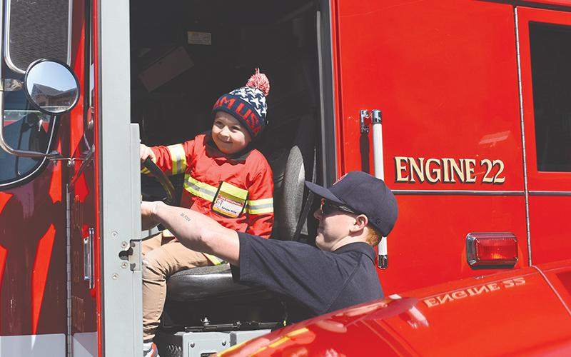 Four-year-old Sawyer Stille takes the opportunity while he’s dressed as a firefighter to honk a real fire truck at the new Cornelia South Station on Saturday.