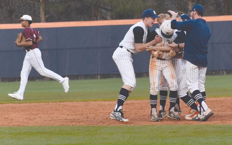 Raider teammates crowd Azzi Cervantes after his eighth-inning RBI single sent Habersham Central home with a 5-4 win over Dawson County on Wednesday.