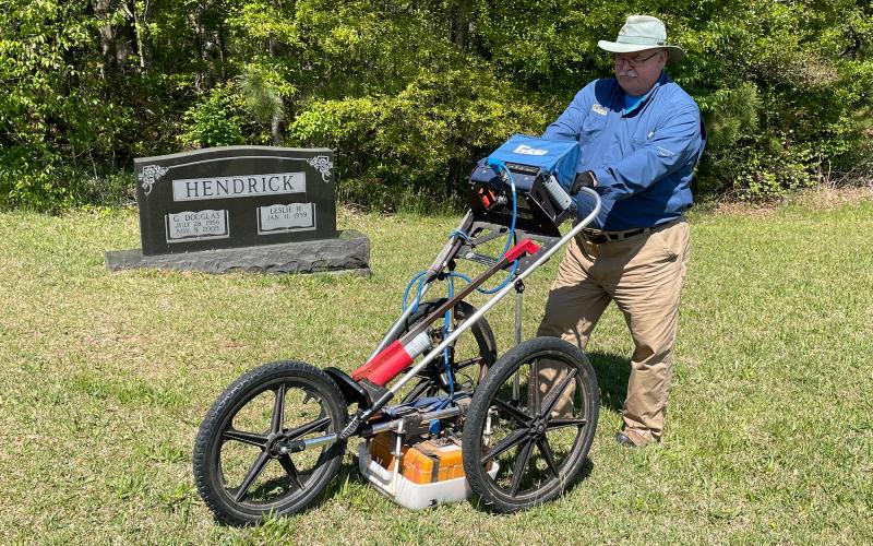 Len Strozier locates unmarked graves at Crossroads Baptist Church Cemetery using a ground-penetrating radar. BRIAN WELLMEIER/Staff