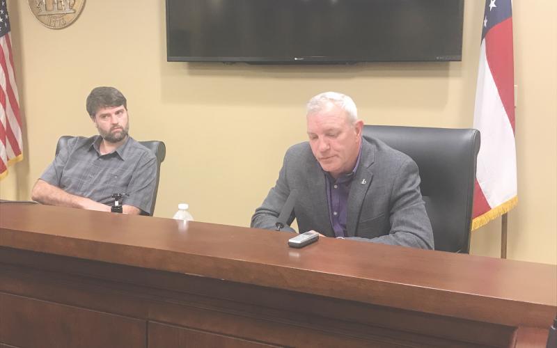 Commissioner Tim Stamey (right) explains his reasons for resigning Monday night as Chairman Dustin Mealor looks on.