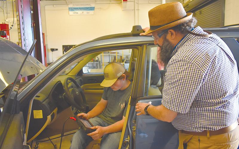 Habersham Central High School Automotive teacher Jimmy Jones oversees the work junior Joshua Newsome is doing during class earlier this year. A new cohort for the automotive dual enrollment program will begin in the fall.