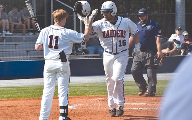 Logan Hare (16) high-fives teammate Austin Jones (11) following a solo home run in the first of two games Wednesday.