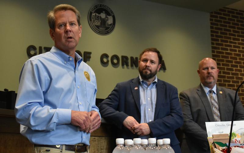 Gov. Brian Kemp (left) talks Thursday at Cornelia City Hall as Mayor John Borrow and City Manager Dee Anderson listen. CHAMIAN CRUZ/Staff