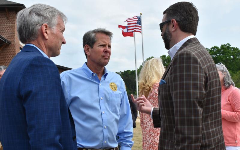 Gov. Brian Kemp talks with Rep. Chris Erwin (left) and Rep. Matt Dubnik outside Cornelia City Hall before Thursday’s bill signing event. CHAMIAN CRUZ/Staff
