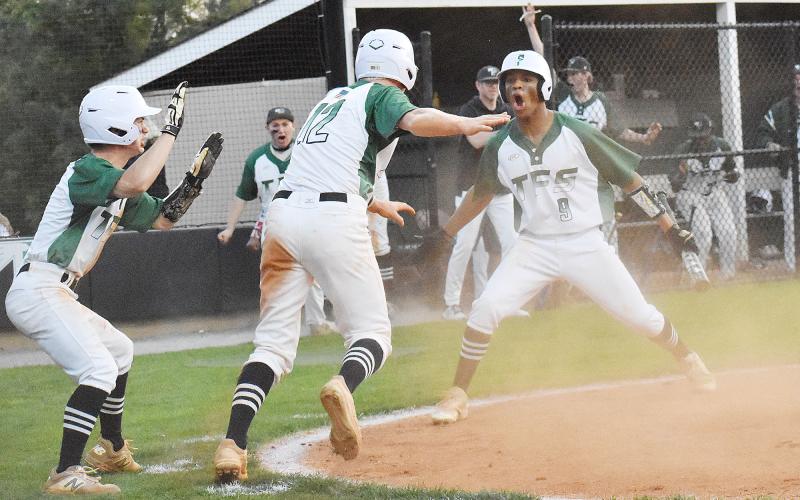 Baylor Carnes, Chathan Clouatre and Malique Charlton celebrate after scoring a couple of late runs in last Tuesday’s game against Athens Christian Academy. CODY ROGERS/Staff