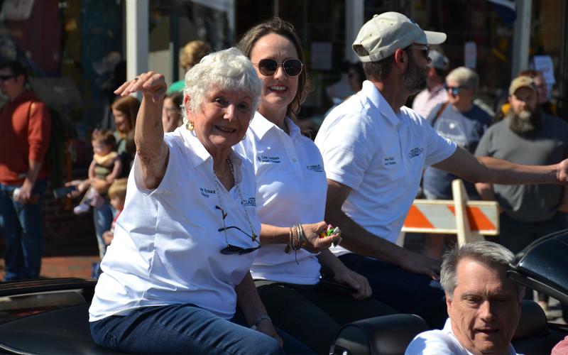 Clarkesville Mayor Barrie Aycock (left) along with city council members Lane Gresham and Steven Ward chuck candy at parade watchers on Saturday morning while rolling through downtown on the back of a convertible. MATTHEW OSBORNE/Staff