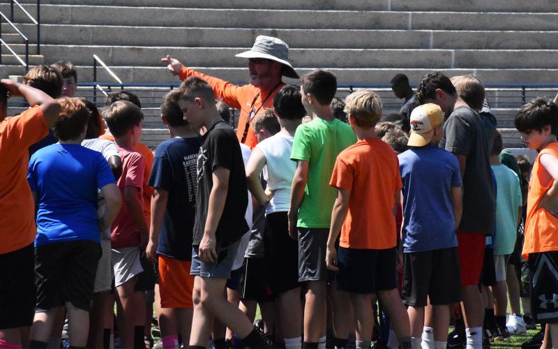 Raiders head coach Benji Harrison speaks to a group of campers at the conclusion of day one’s drills and stations. ISAIAH SMITH/Staff