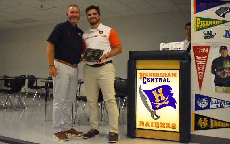 Raiders head coach Benji Harrison (left) presented Hadden Carswell with the Jimmy Williams Courage Award during the Ring of Honor banquet Thursday night. ISAIAH SMITH/Staff