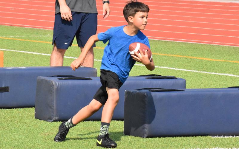 Everett Smith moves through pads with the football during camp. ISAIAH SMITH/Staff