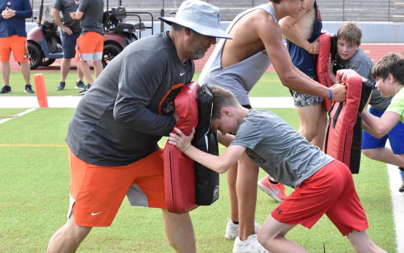 Raiders coach Shane Dover (left) takes on a block from Will Gailey (right) at the blocking station during the Future Raiders Football Camp.  ISAIAH SMITH/Staff