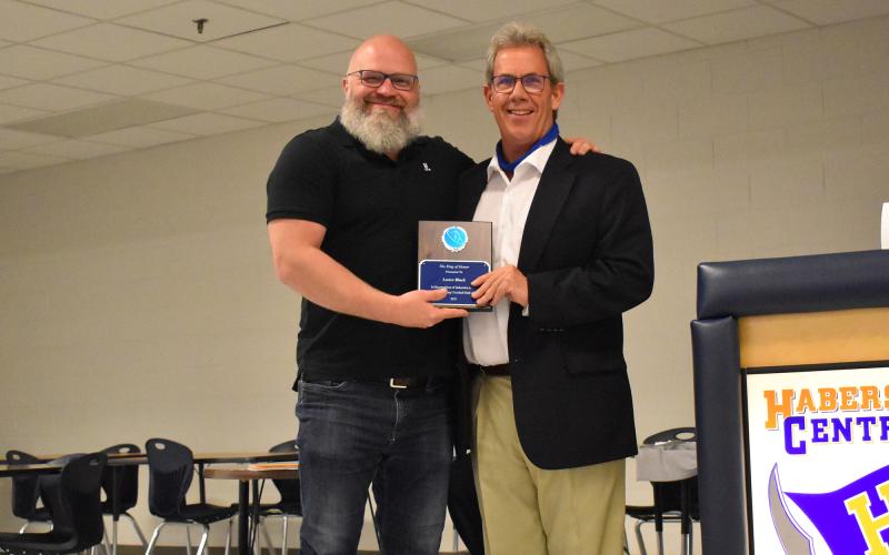 Lance Black (left) receives a formal induction into the Ring of Honor from his former head coach Mark Fleetwood (right). ISAIAH SMITH/Staff