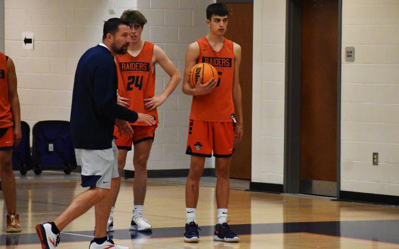 New Habersham Central head coach Aric Mawdesley (left) explains how a drill relates to the team’s offensive philosophy while Kaden Hooks (center) and Mekhi Mawdesley (right) look on. ISAIAH SMITH/Staff