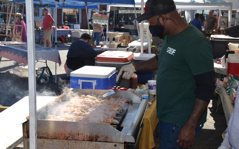 Triamaine Perry cooks up chicken at one of the delicious food vendor stations at the  Mountain Laurel Festival on Saturday. MATTHEW OSBORNE/Staff