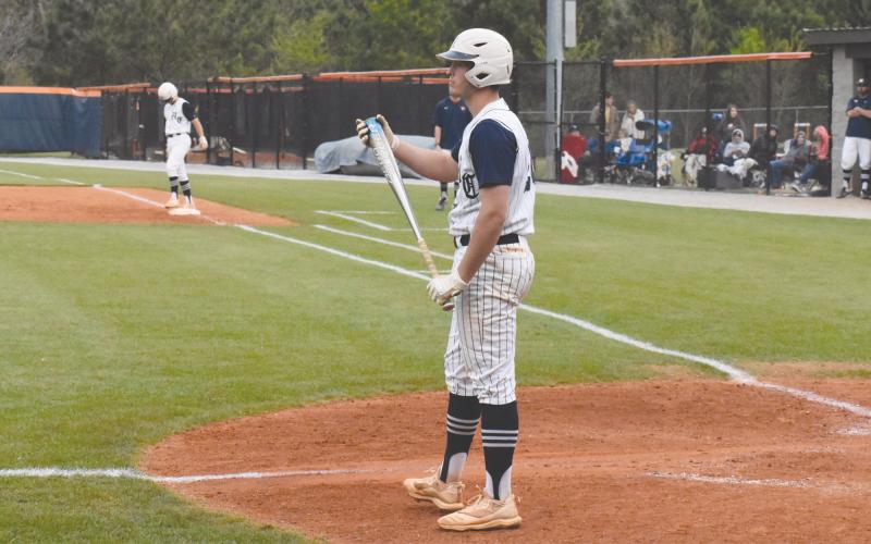 Sutton Dover takes a sign from head coach Chris Akridge before stepping back into the box. Dover went 4-6 over the Raiders’ two state playoff games with two RBI and a home run. ISAIAH SMITH/Staff