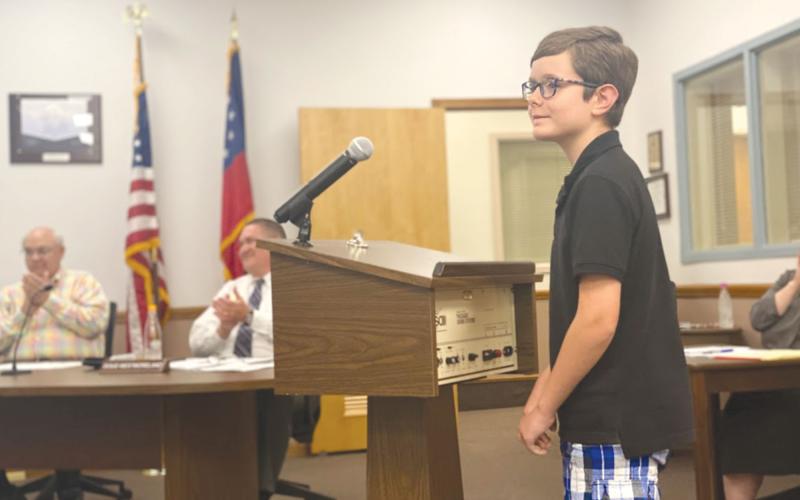 Erik Jordan, a fourth-grade student at Woodville Elementary School, read his award-winning poem to the Habersham County Board of Education on Monday, to the delight of board members Robert Barron and Doug Westmoreland. CHAMIAN CRUZ/Staff
