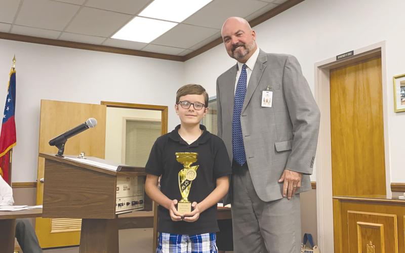 Erik Jordan shows off his trophy with Superintendent Matthew Cooper. CHAMIAN CRUZ/Staff