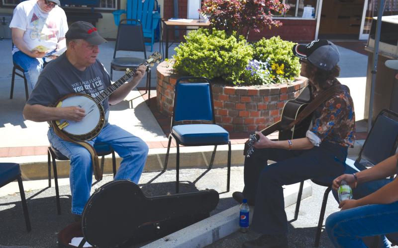 Jack Ball and Brandon Dover pick and grin while they play some impromptu music for  passersby during the Mountain Laurel Festival. MATTHEW OSBORNE/Staff