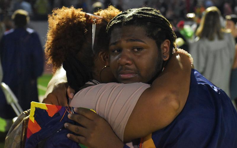 Xavier Reid gets a hug on the field from a family member. MATTHEW OSBORNE/Staff