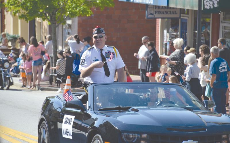 Grand Marshal Bill Miles waves his flag to the onlookers.