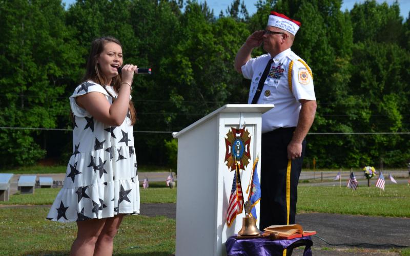 Shayanne Rinefierd sings the Star-Spangled Banner at the Memorial Day ceremony at the VFW Memorial Park in Demorest on Monday morning. BRIAN WELLMEIER/Staff