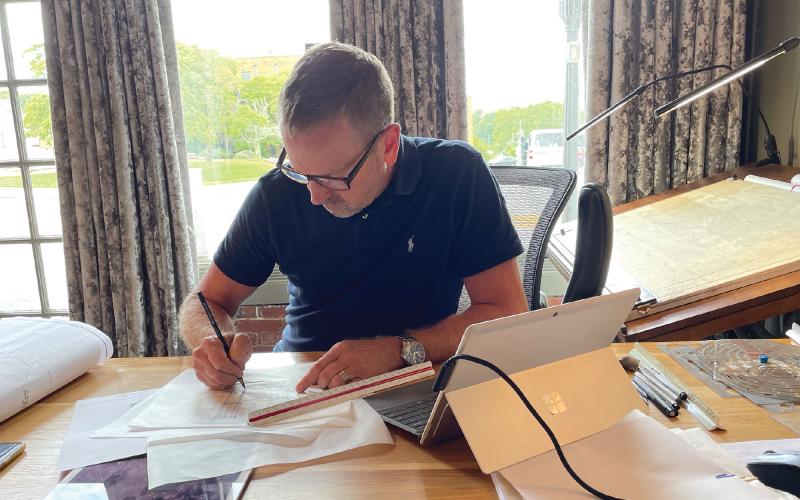 Lew Oliver drafting architectural designs at his office in downtown Clarkesville