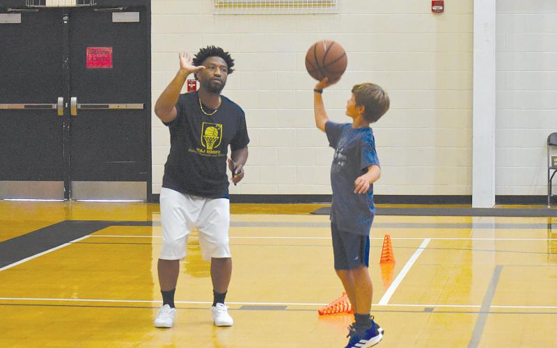 Evan Sims (right) works with coach Shamir Dooley on getting his form correct before taking a shot during camp. ISAIAH SMITH/Staff