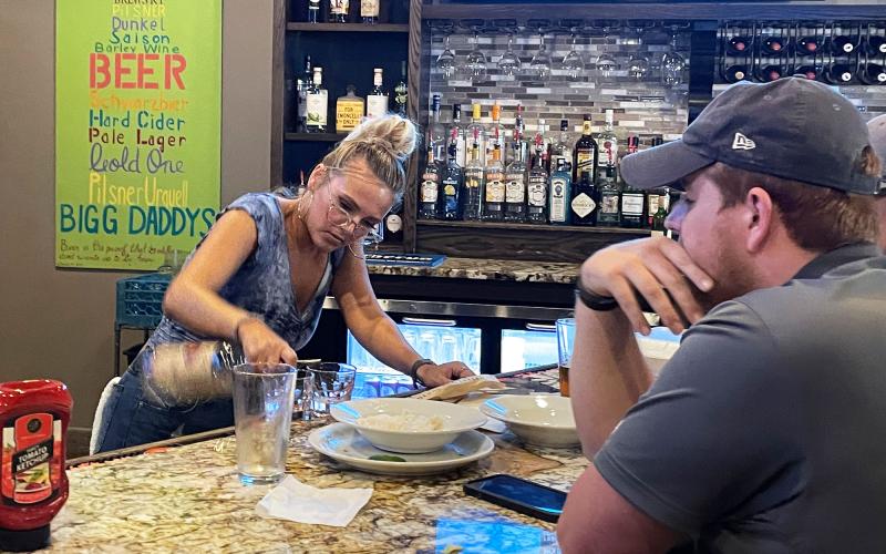 Bigg Daddy’s bartender Mary Childers serves patrons at the bar. While Bigg Daddy’s has a solid staff for now, other local restaurants are still seeking more staff as the pandemic abates. BRIAN WELLMEIER/Staff