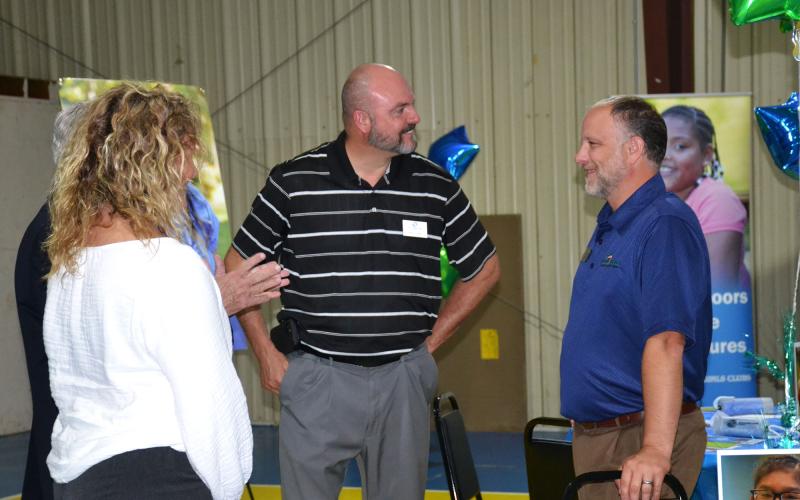 Superintendent Matthew Cooper talks with John Fair, Chief of Staff of Peach State Credit Union, at the Tim Lee Boys &amp; Girls Club open house on June 17. BRIAN WELLMEIER/Staff